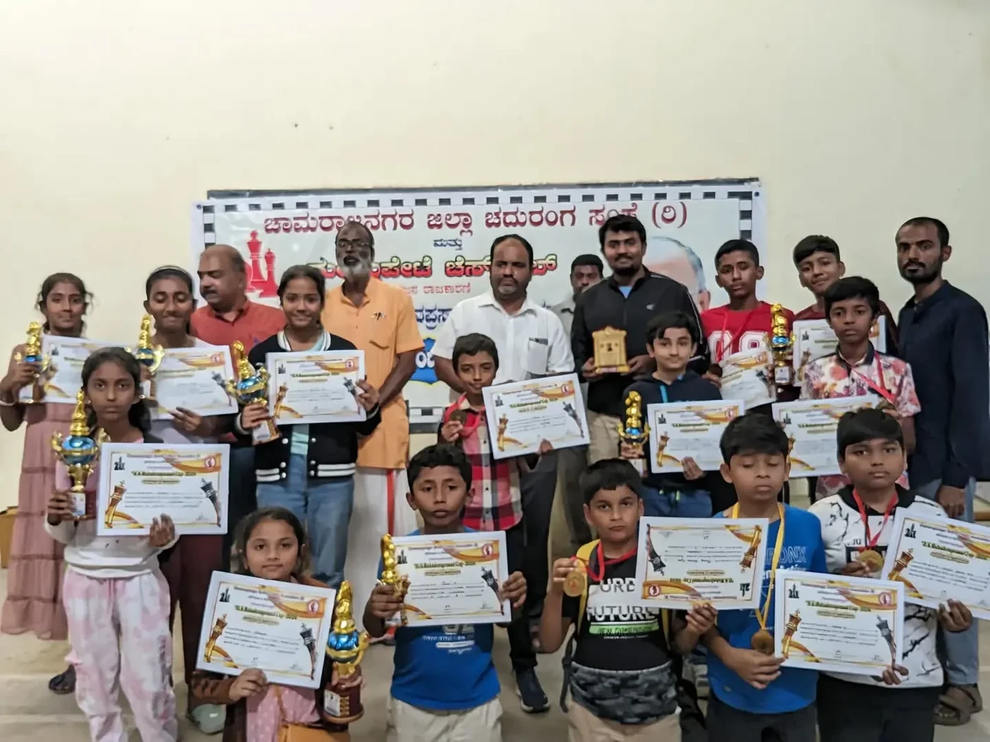 Chess students with certificates and trophies at an award event