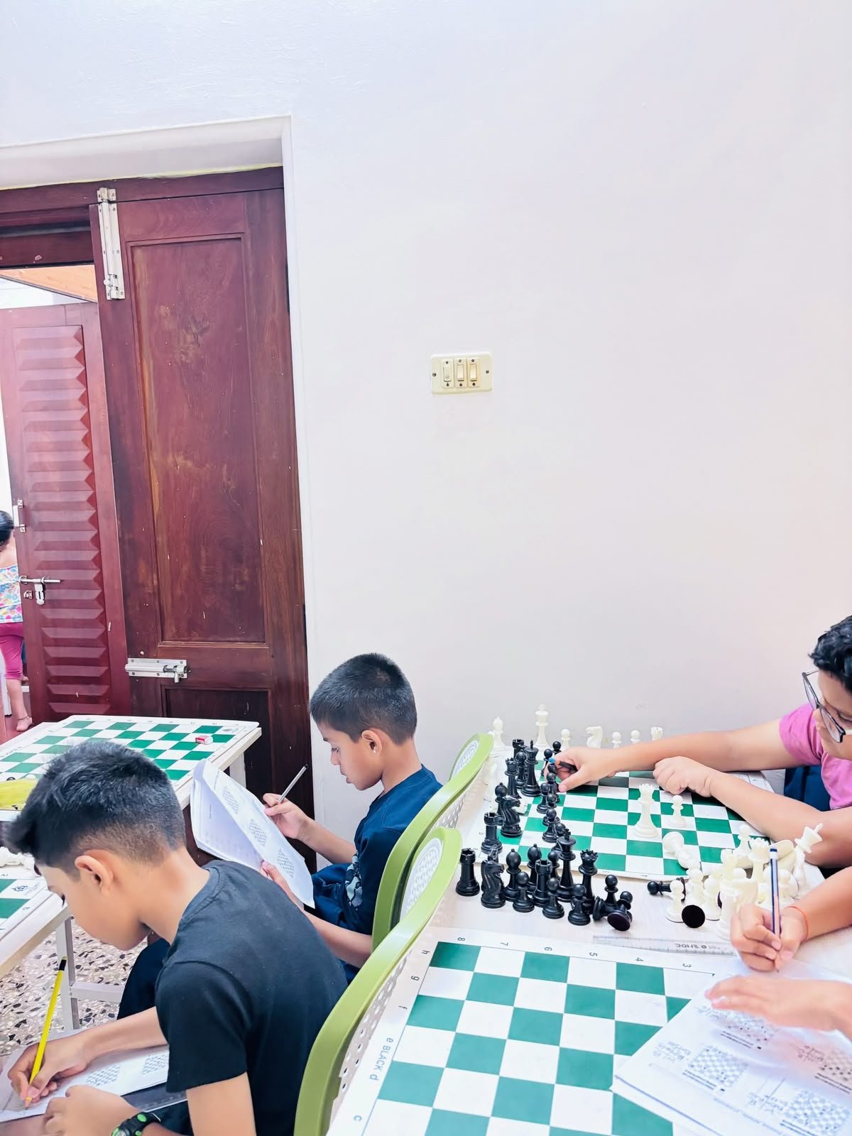 Children practising chess notation and board positions